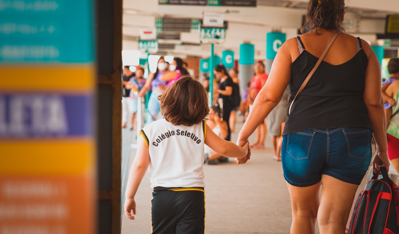 estudante andando no terminal de ônibus